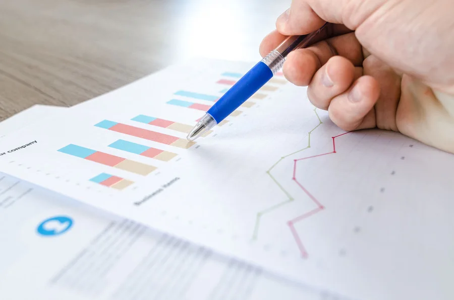 A pen indicating charts on a printed report.